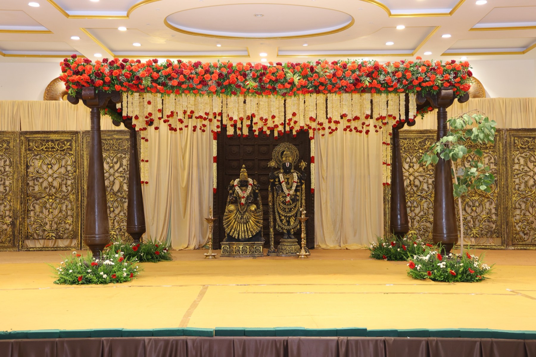 Traditional floral mandap with temple deities by House of Muhurtam