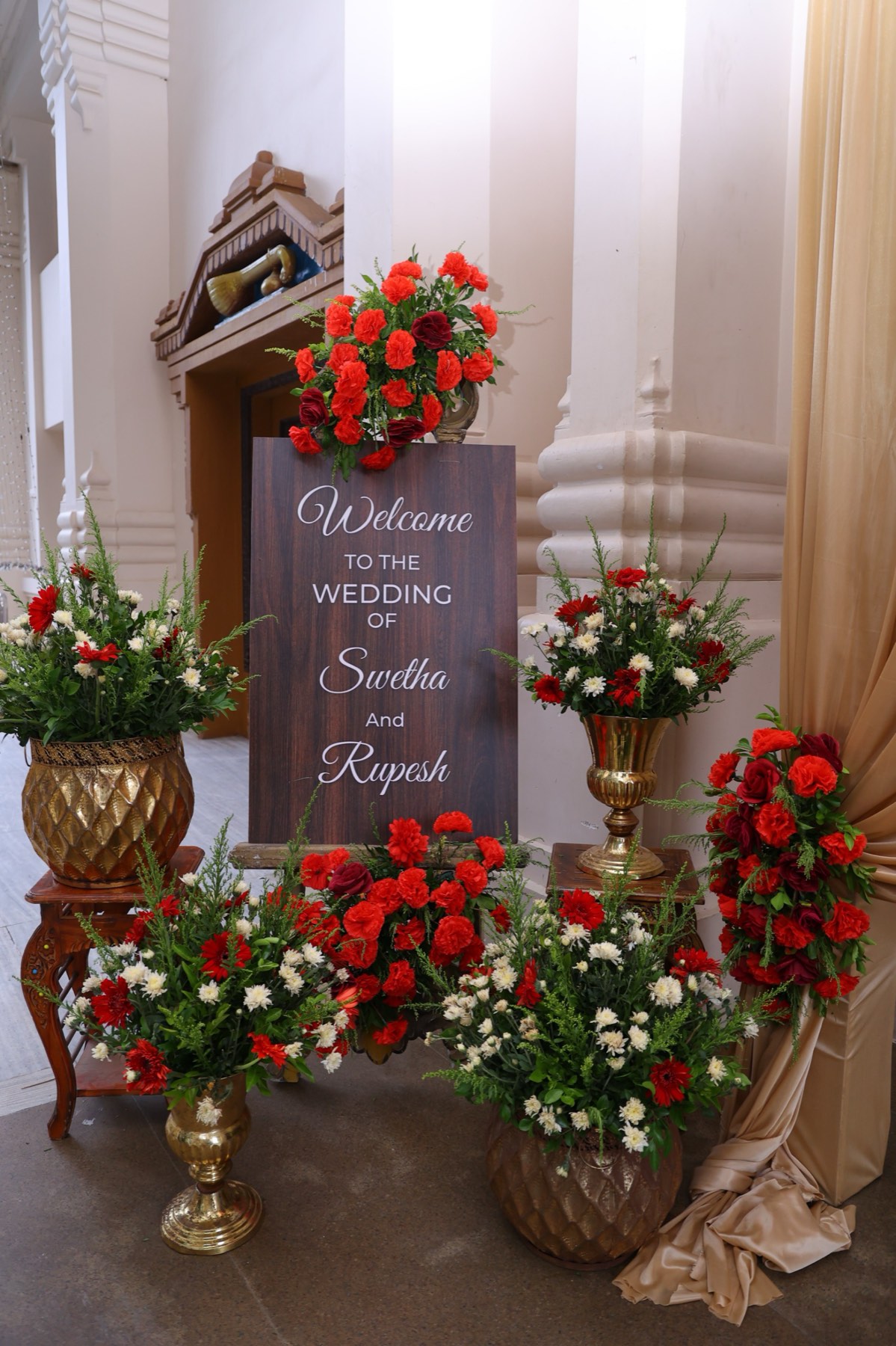 Floral welcome signage with brass urns by House of Muhurtam